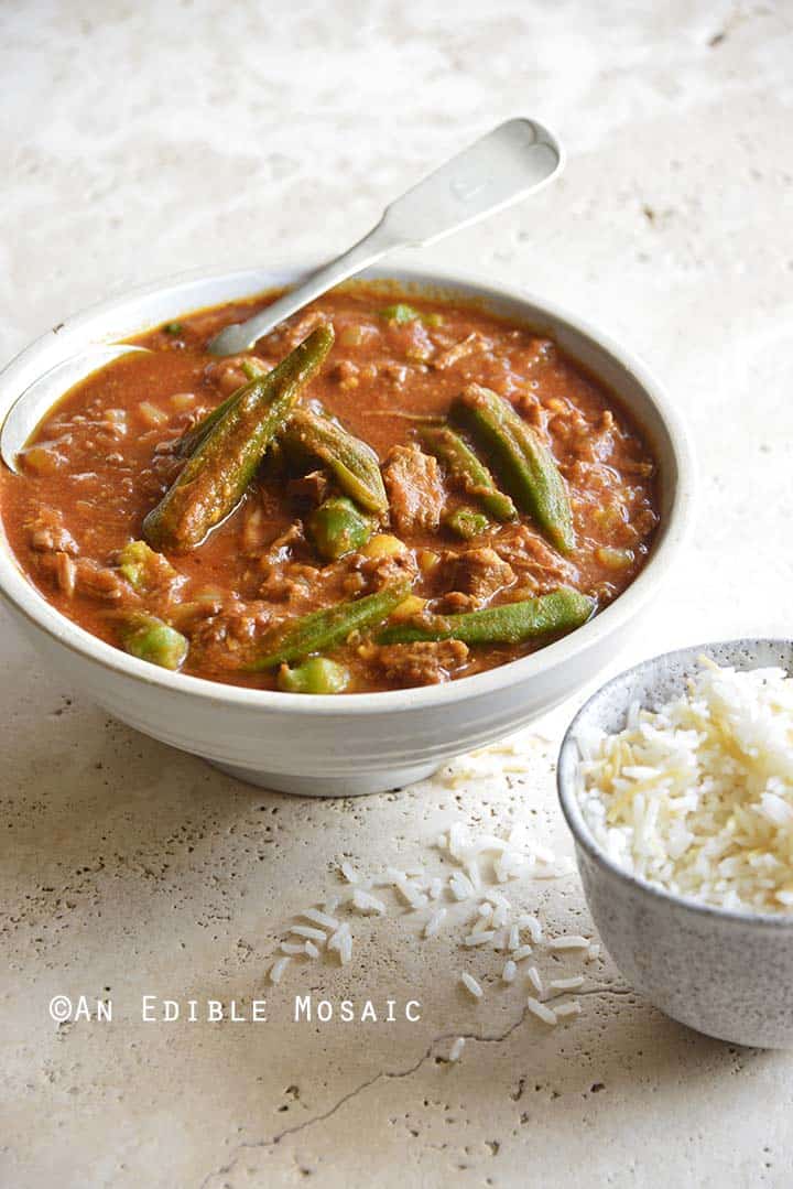 Persian Okra Stew (Khoresh Bamieh) on Rough Concrete Table