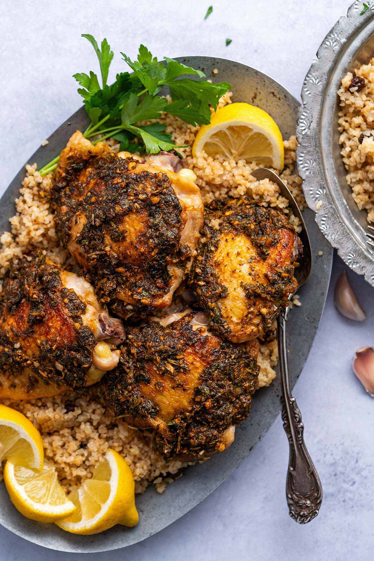chermoula chicken on platter with couscous pilaf