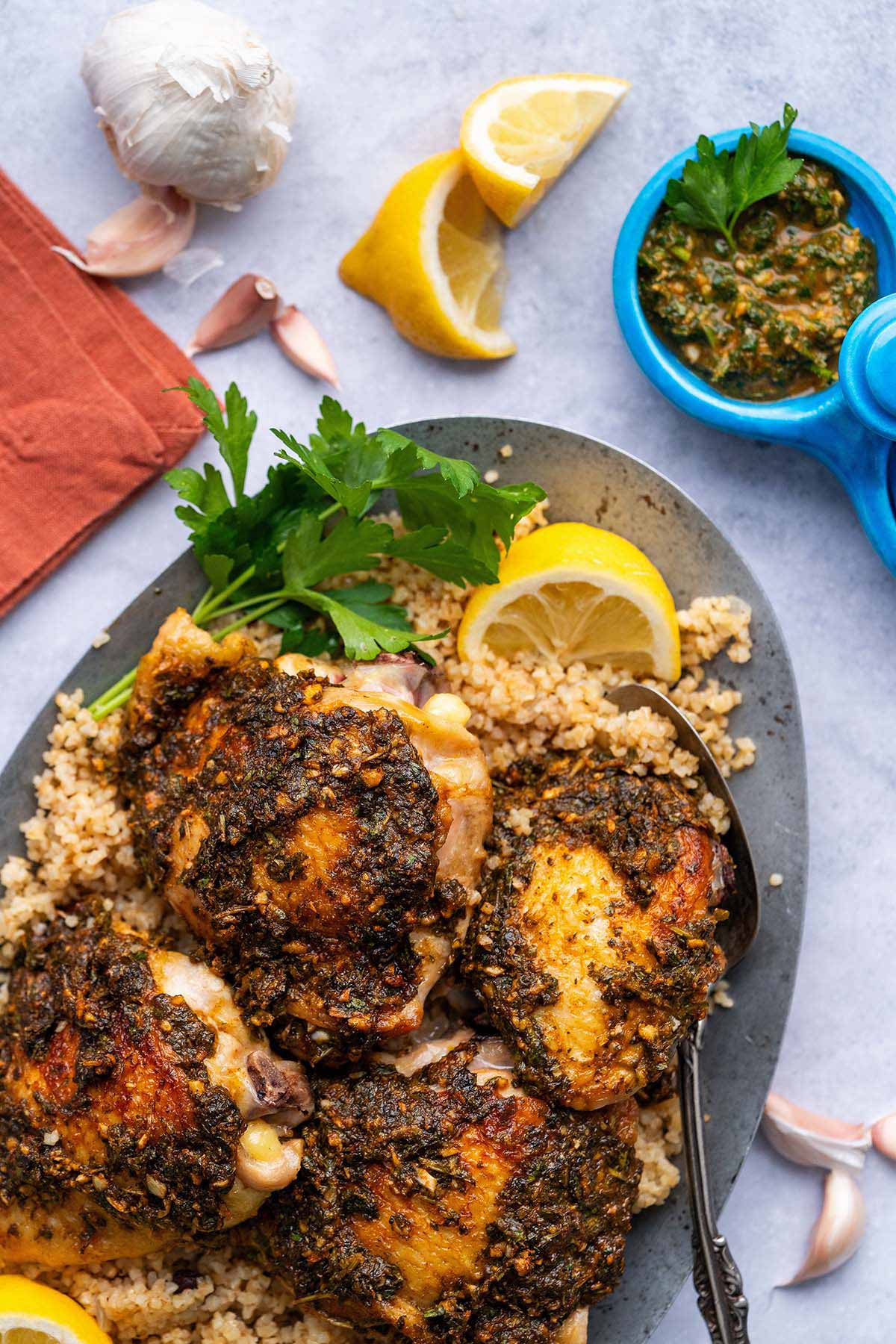 chermoula chicken with bulgur wheat pilaf and small tagine with sauce