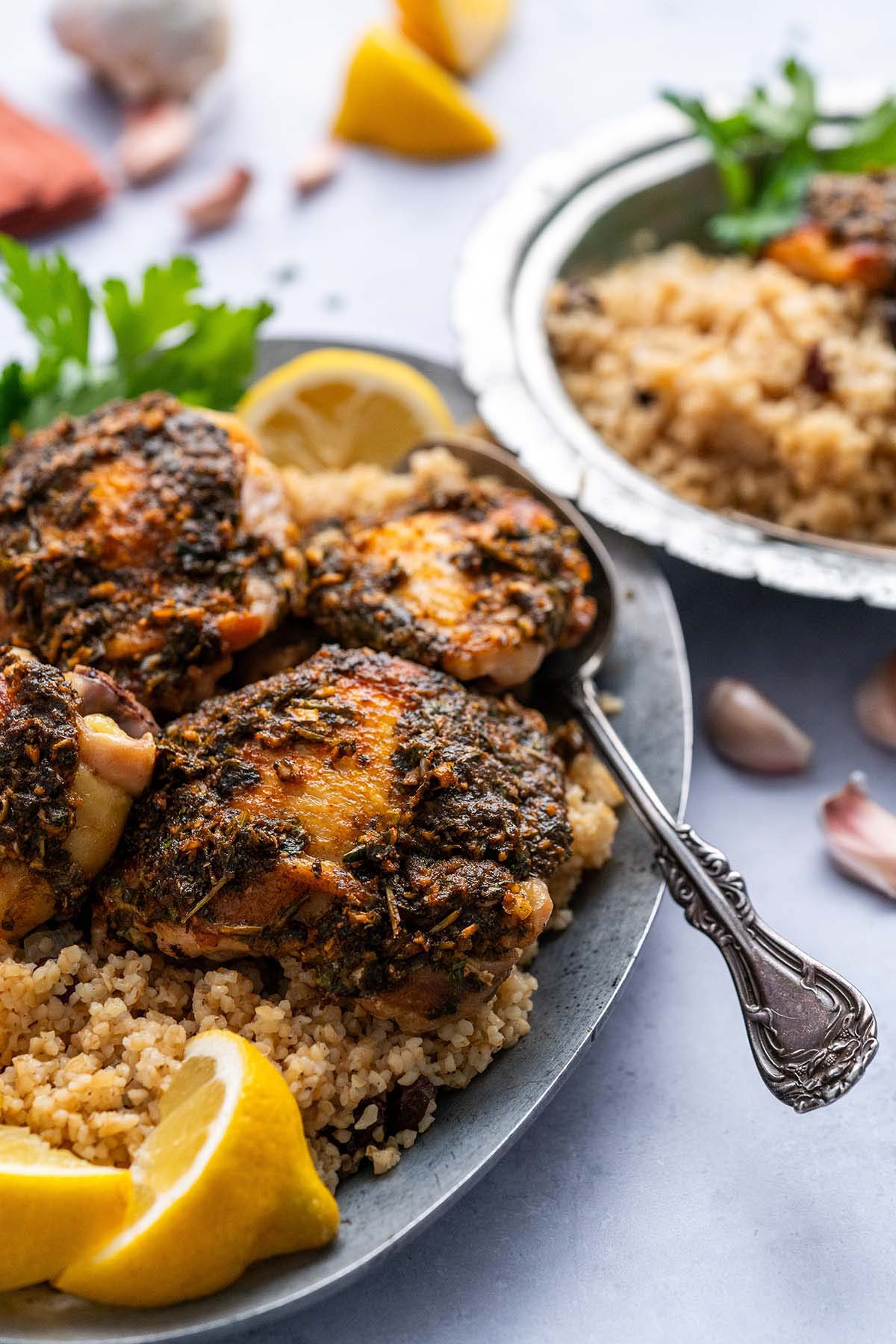 front view with serving platter of Chermoula chicken thighs and raisin bulgur pilau