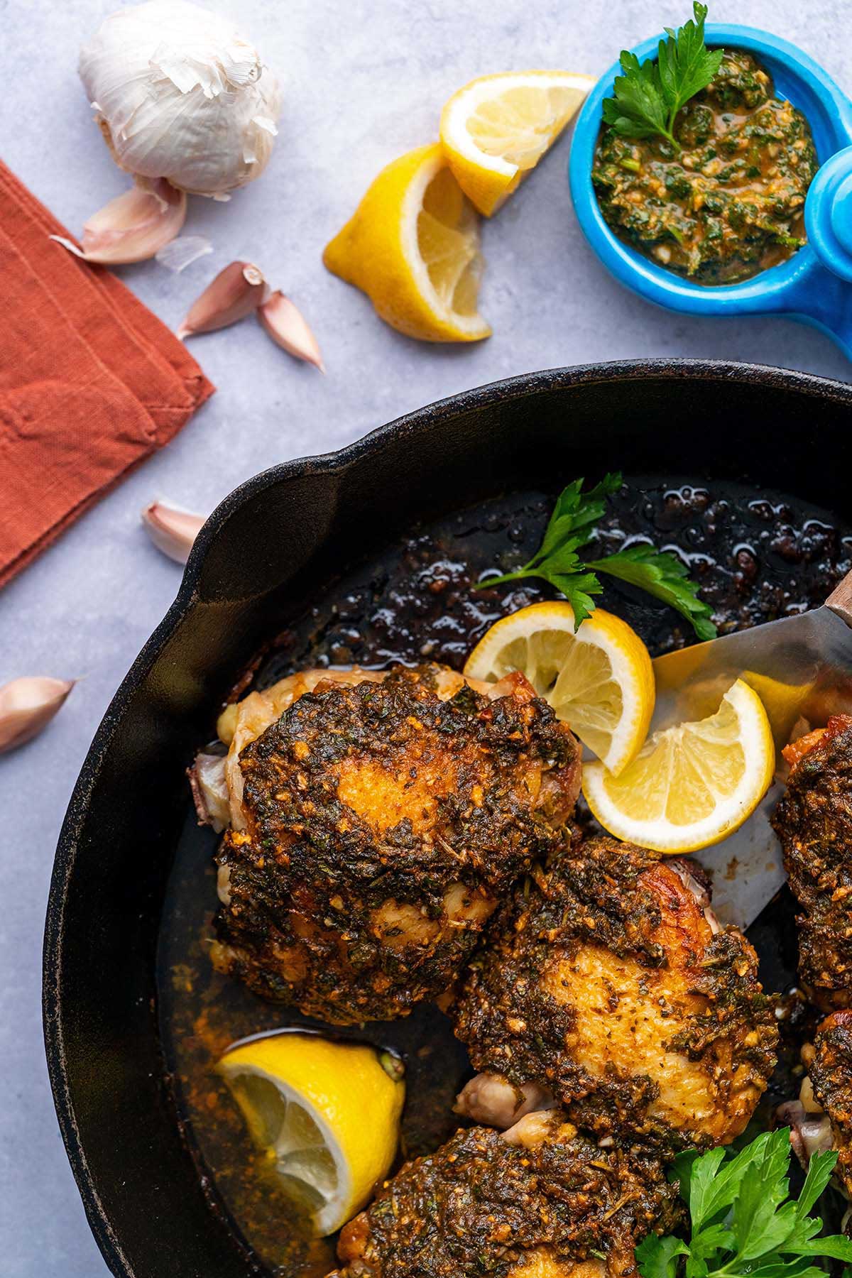 moroccan Chermoula chicken in cast iron skillet with Chermoula sauce on side