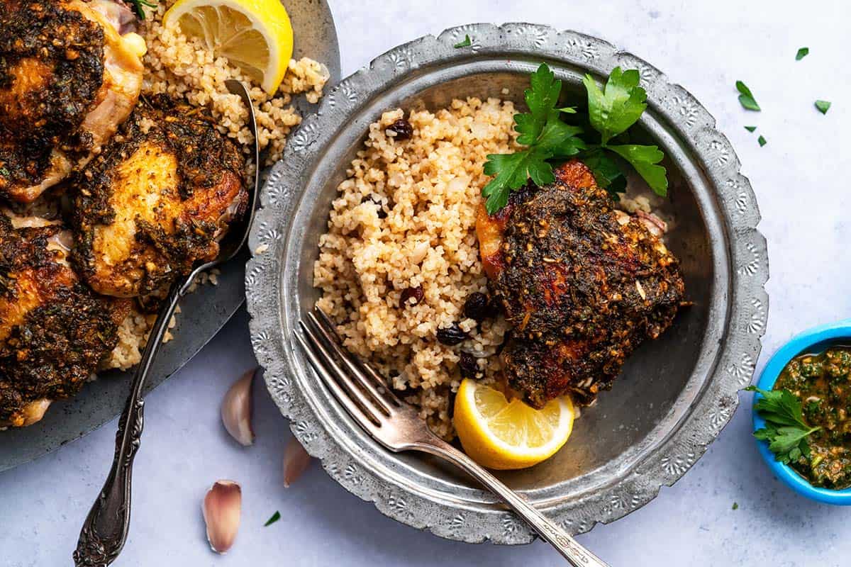 overhead view of chermoula chicken meal with couscous or bulgur pilaf
