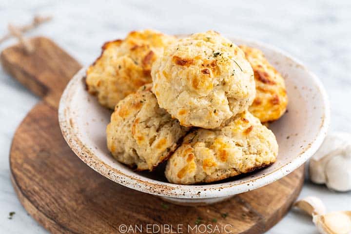 bowl of garlic bread drop biscuits on wooden bread board