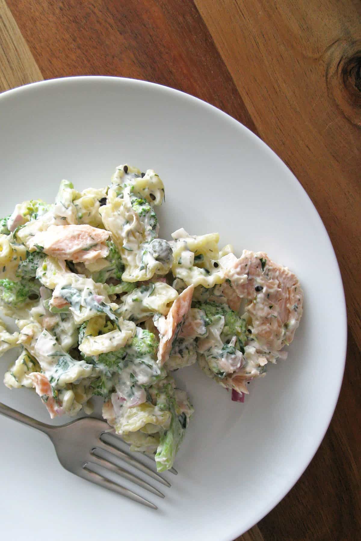 serving of creamy poached salmon pasta salad on plate with fork