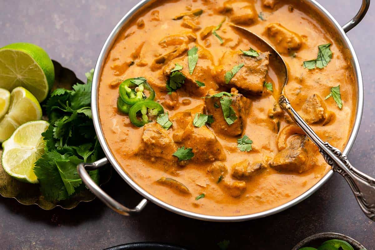 close up of lamb tandoori with tikka masala sauce in serving dish