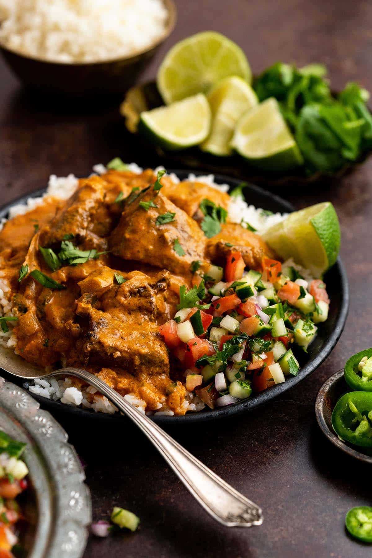 front view of serving of lamb tikka masala with basmati rice and shirazi salad