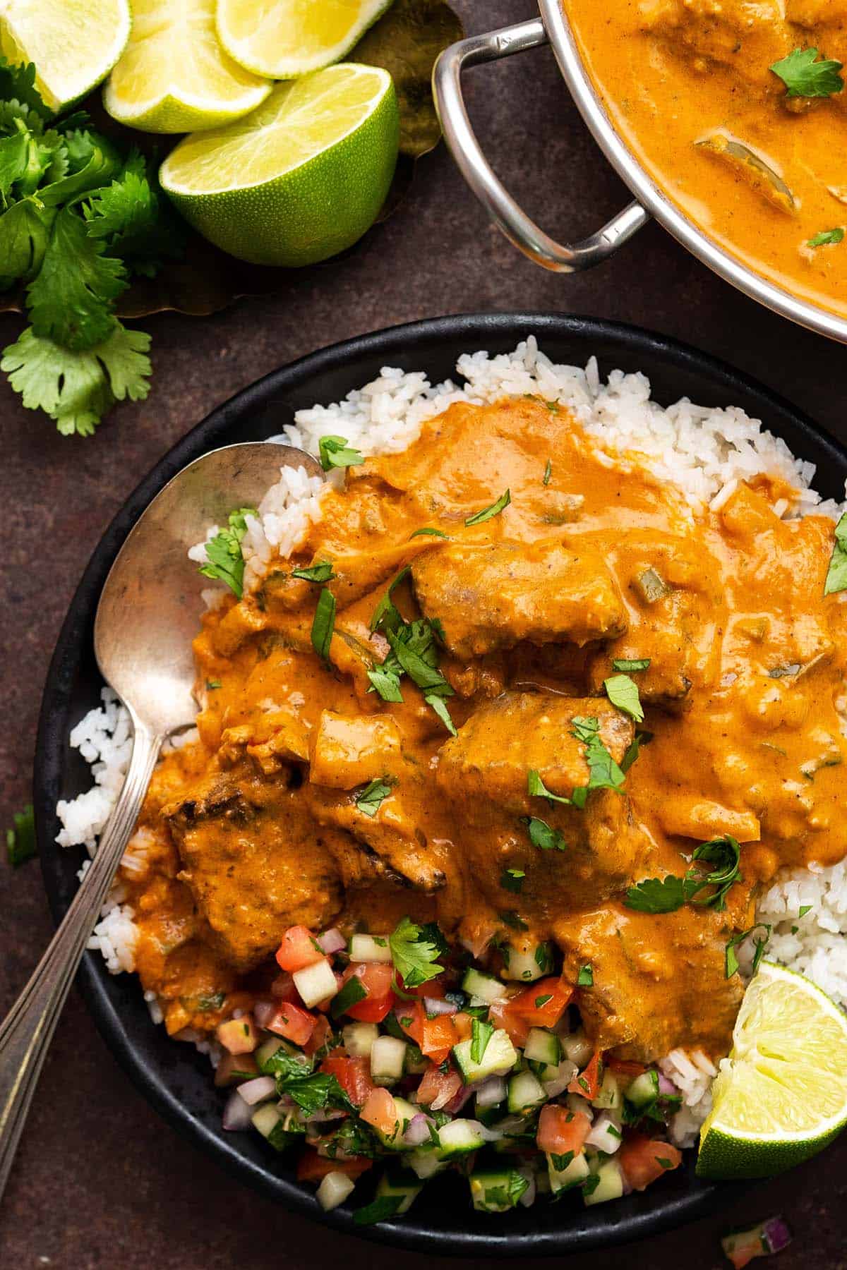 overhead view close up of plate of tikka masala lamb with basmati rice and shirazi salad