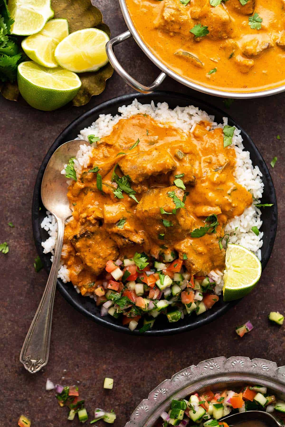 overhead view portion of lamb tikka masala with rice and chopped salad on plate