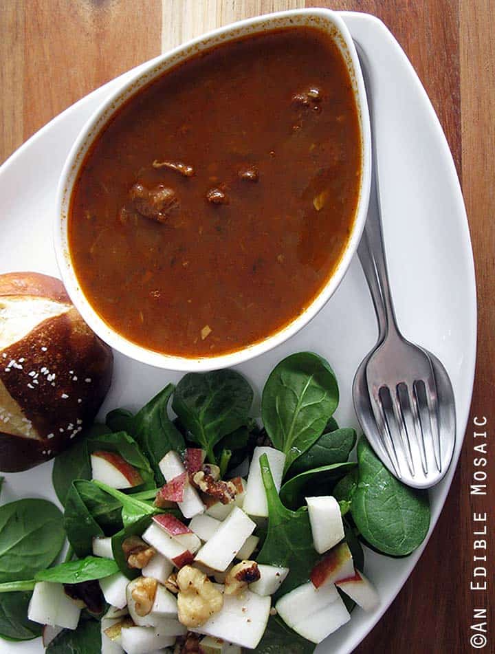 Gulaschsuppe (German Goulash Soup) in White Bowl with Side Salad