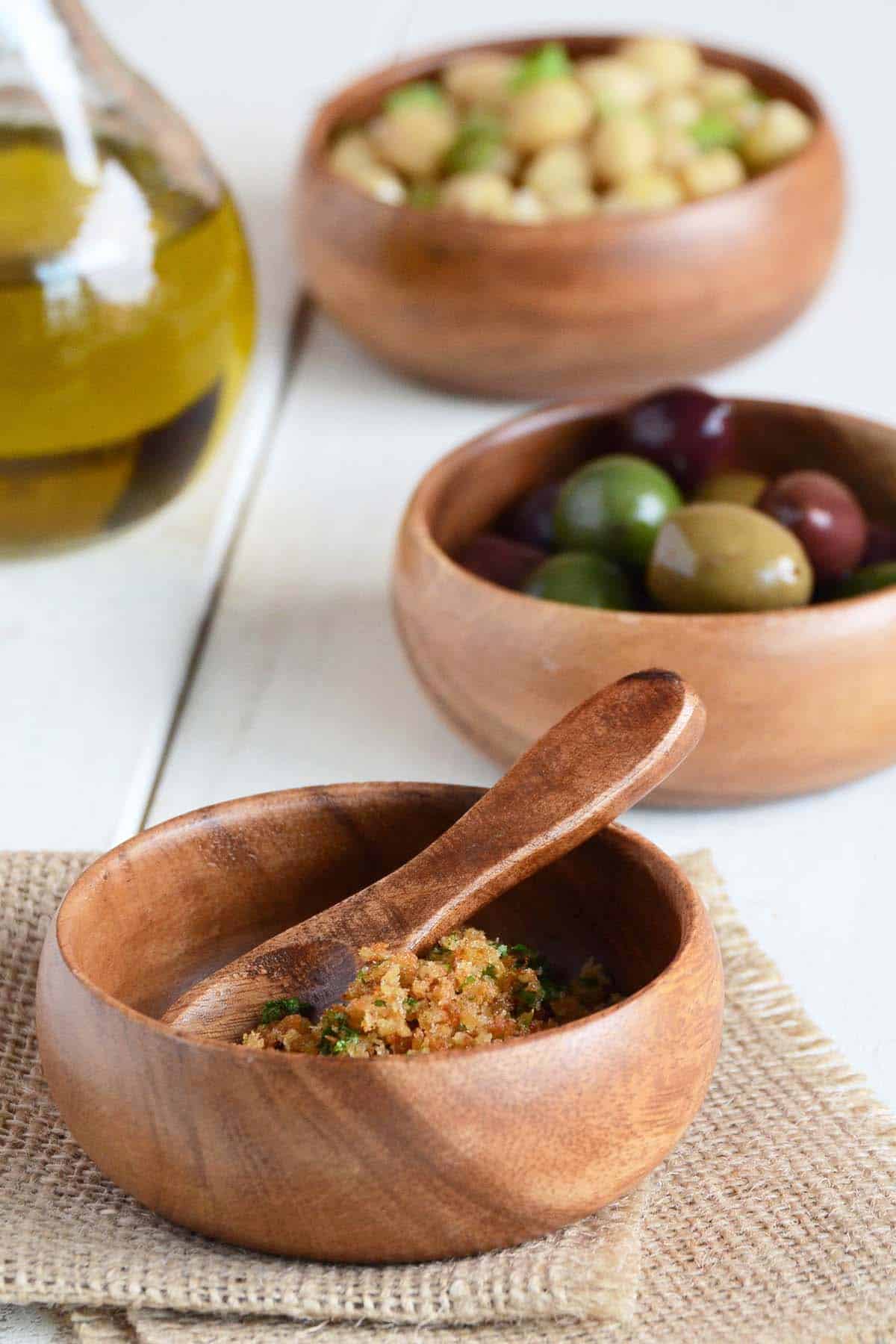 bread crumbs olives and chickpeas in wooden bowls