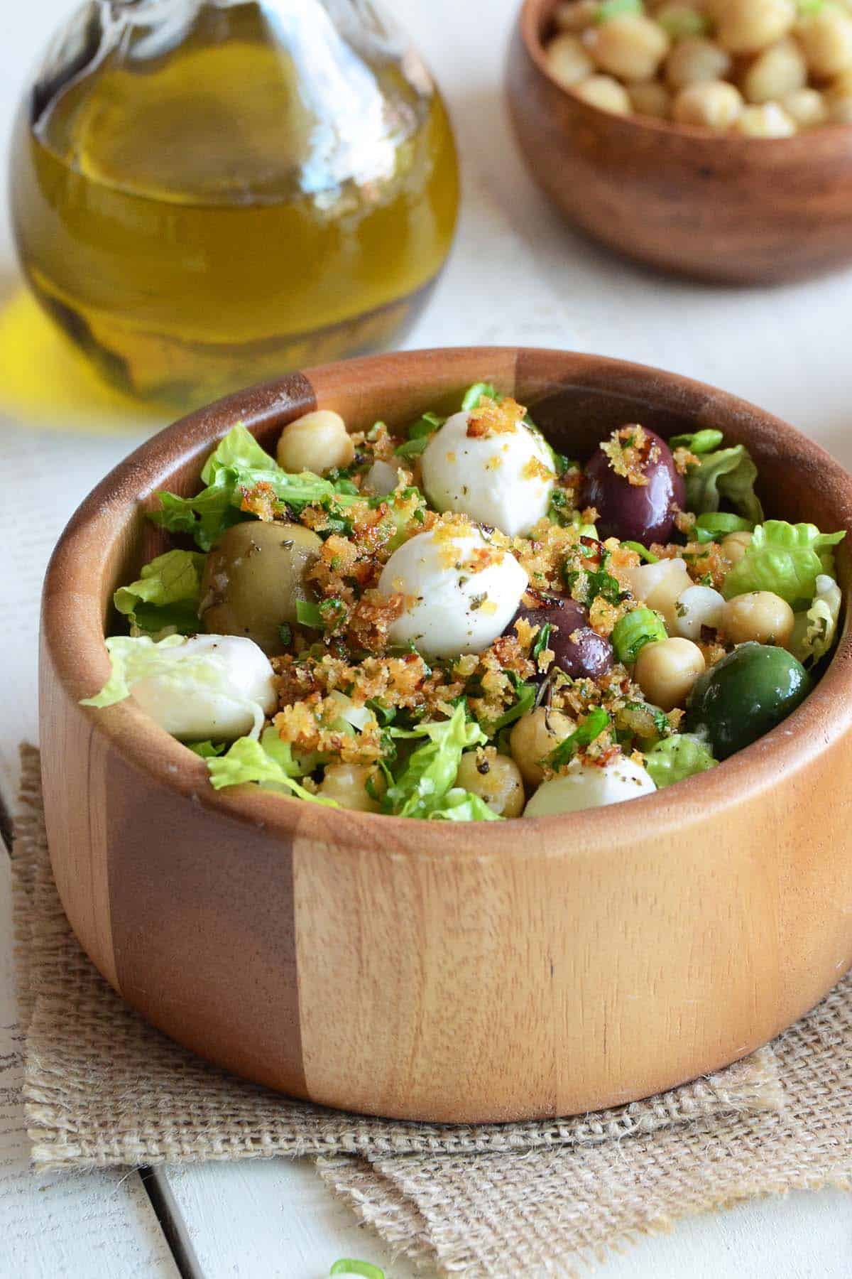 close up front view of bread crumb salad with olives mozzarella and chickpeas