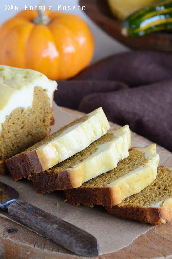 Easy Pumpkin Bread Recipe Sliced on Cutting Board with Baby Pumpkin