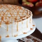 Caramel Apple Cake on White Cake Stand with Apples in Background