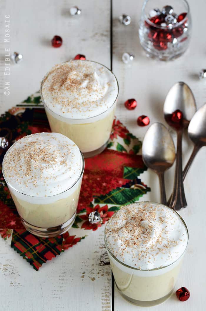 Eggnog Pudding on White Wooden Table with Festive Christmas Fabrics and Small Jingle Bells