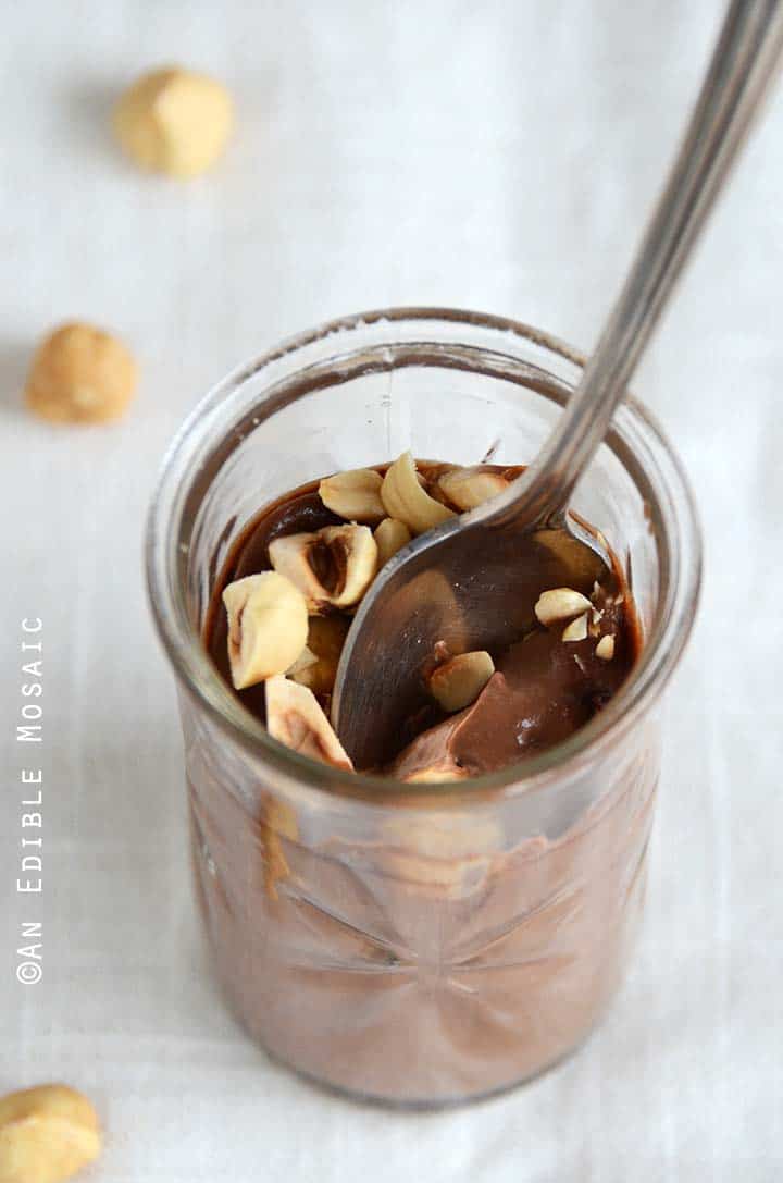 Chocolate-Hazelnut Custard on a White Fabric with a Spoon