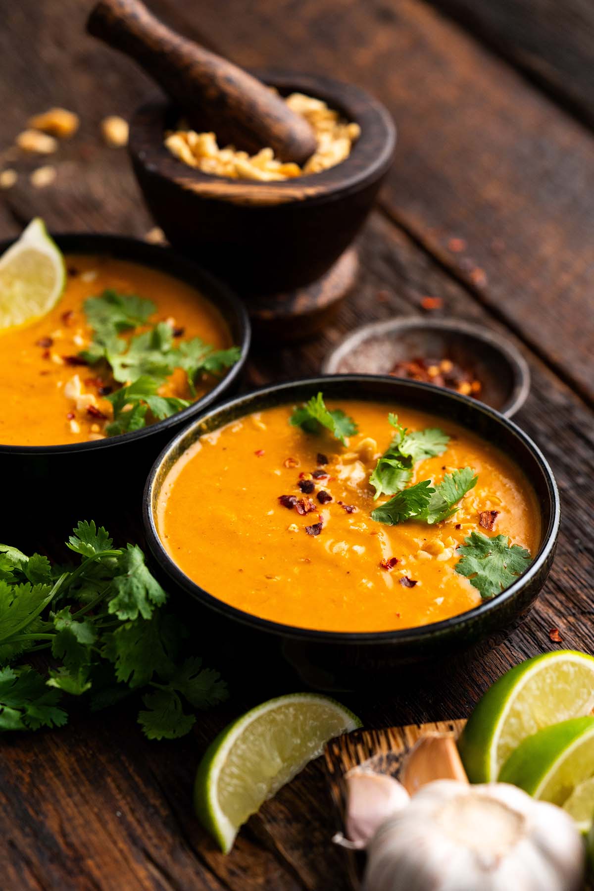 front view of bowls of thai pumpkin soup with peanuts