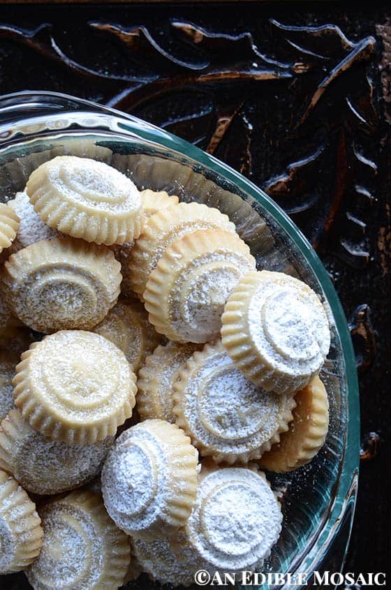 Glass Bowl of Maamoul Cookies on Dark Ornate Wooden Table