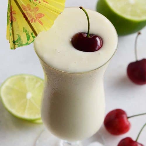 Healthy Pina Colada Smoothie with Fresh Cherry and Yellow Umbrella Garnish