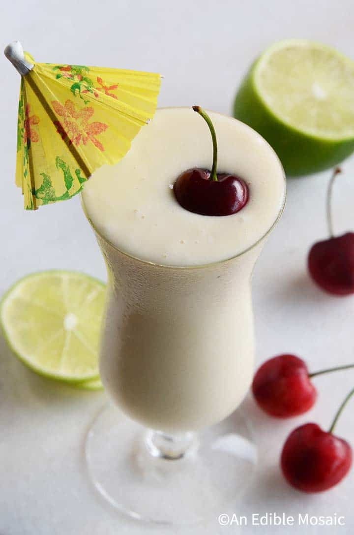 Healthy Pina Colada Smoothie with Fresh Cherry and Yellow Umbrella Garnish