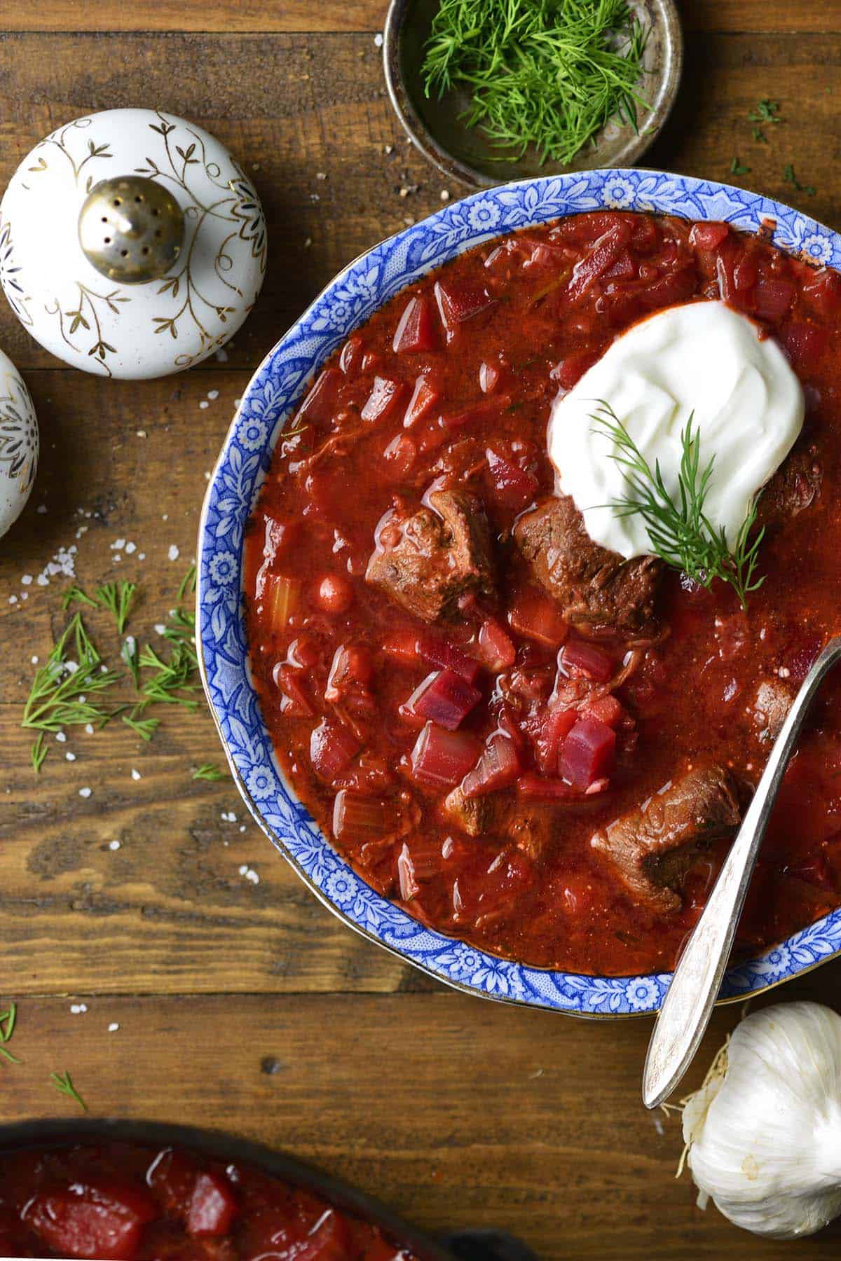 overhead view of borscht russian beet soup in blue and white bowl