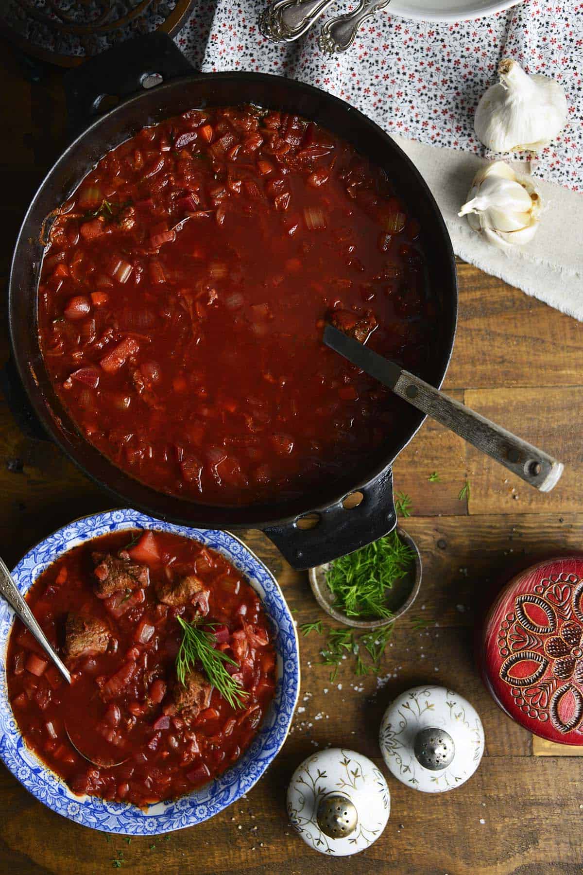 pot of red beef and beet borscht soup with individual bowl next to it