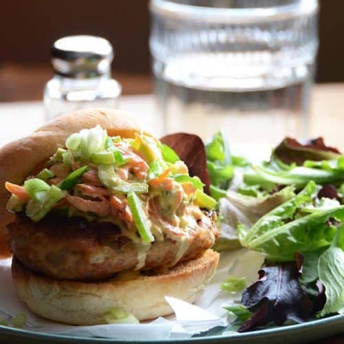 Front View of Buffalo Chicken Burgers with Glass of Water in Background