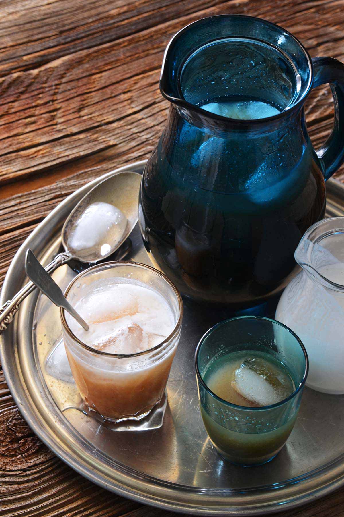wood apple juice with pitcher of juice and jug of coconut milk