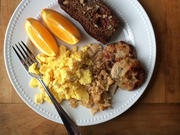 Scrambled eggs, cauliflower hash, homemade apple-onion chicken breakfast sausage, and toasted grain-free cranberry-pecan bread.