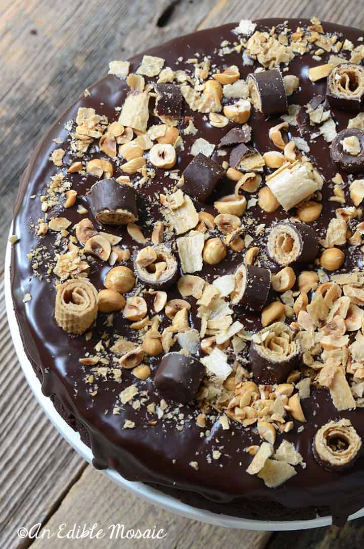 Close Up of Chocolate Hazelnut Cake Showing Crumbled Cookies and Toasted Hazelnuts on Top