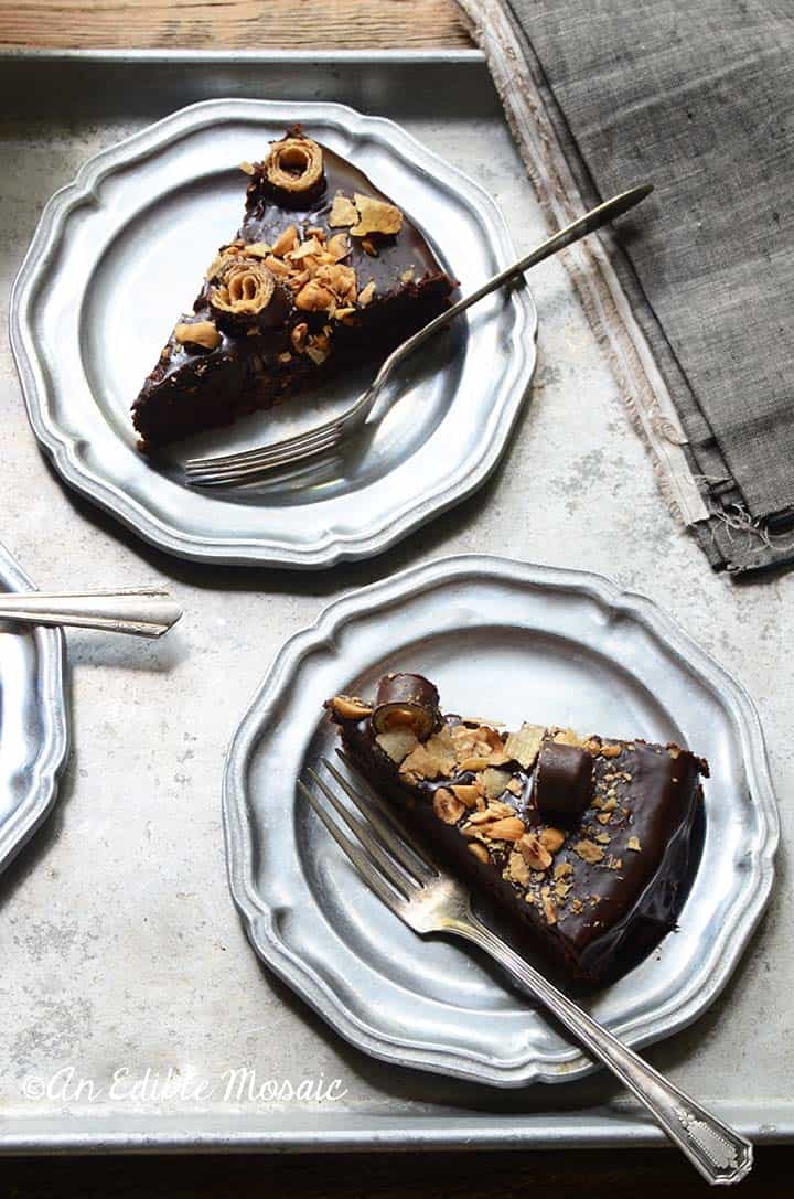 Two Slices of Chocolate Hazelnut Cake on Metal Plates with Vintage Forks