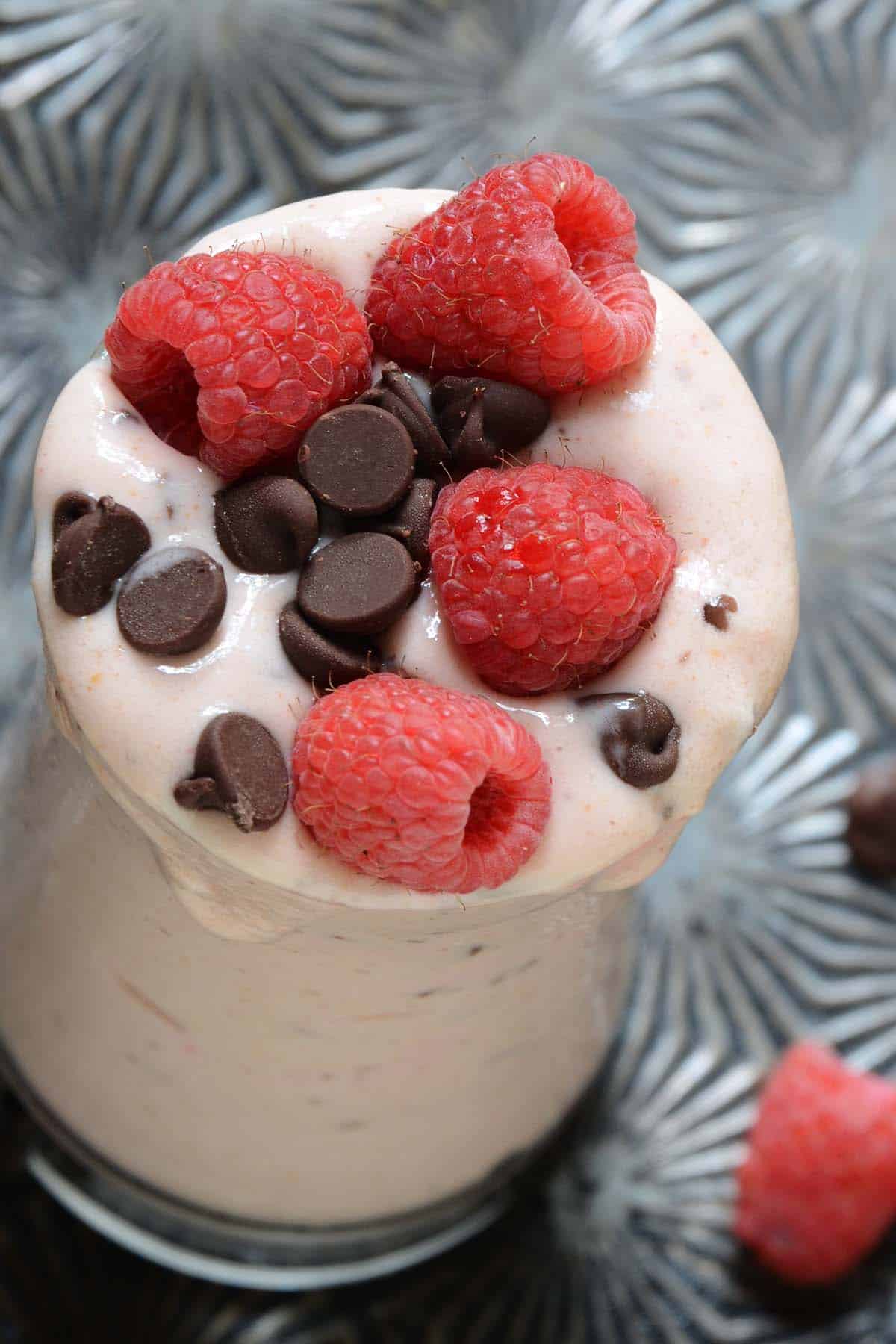 close up top view of healthy chocolate raspberry cheesecake milkshake