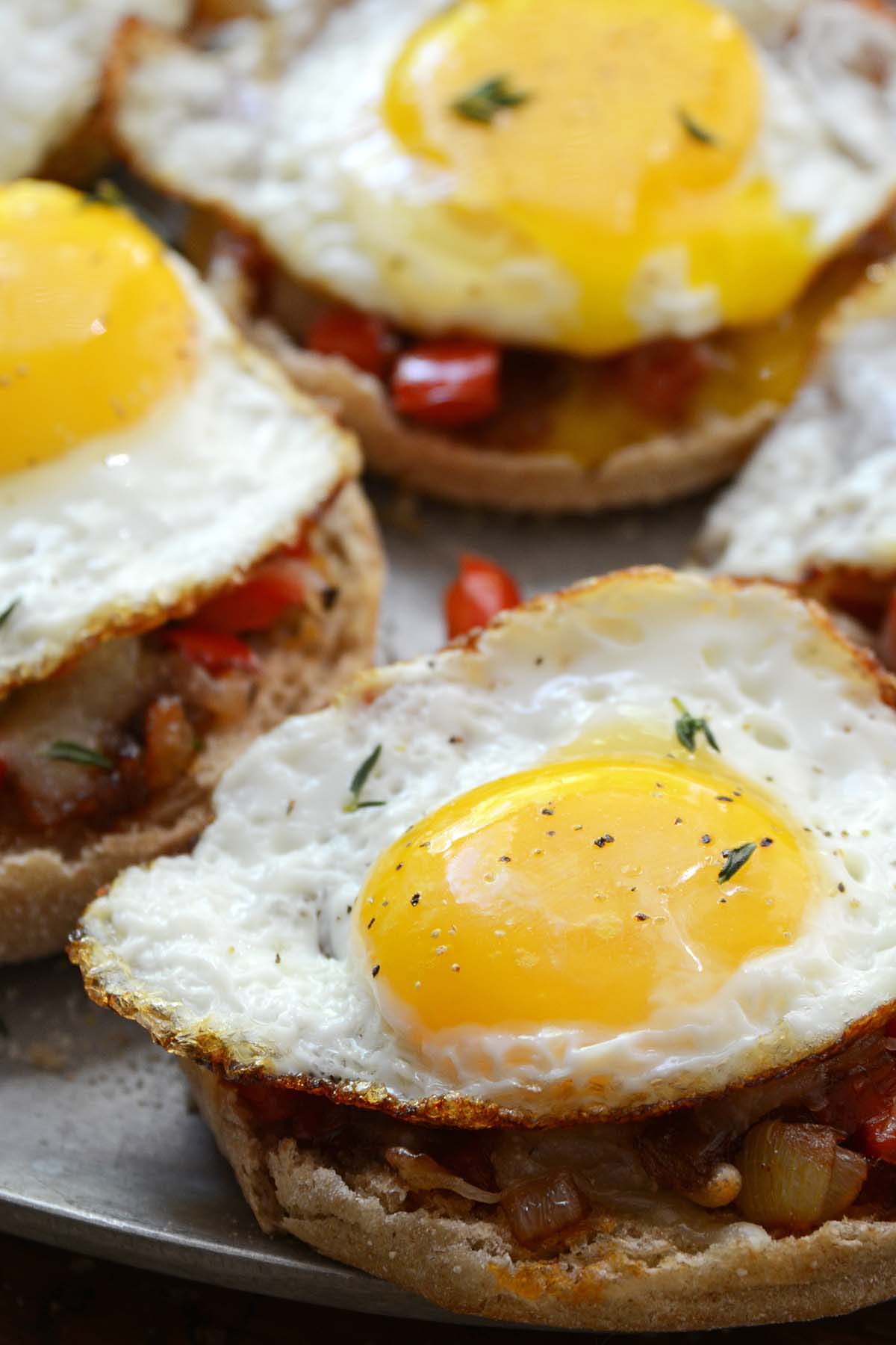 front view of runny eggs on cheesy open face English muffins for brunch
