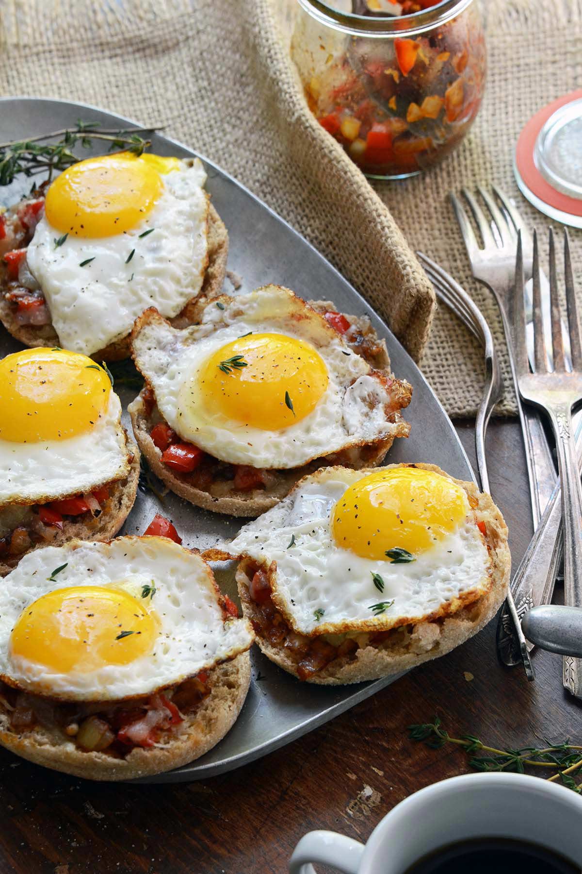 sunny side up eggs on cheesy English muffins with red pepper compote