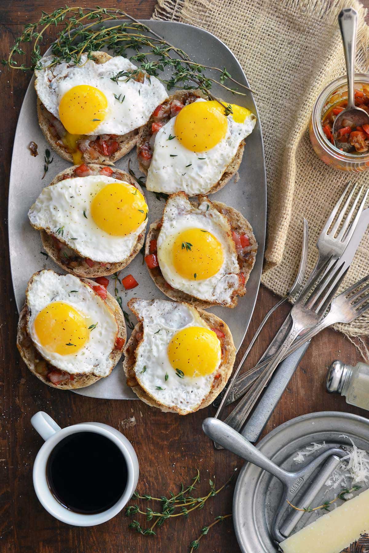 top view of platter of English muffin topped with egg and cheese and red pepper compote
