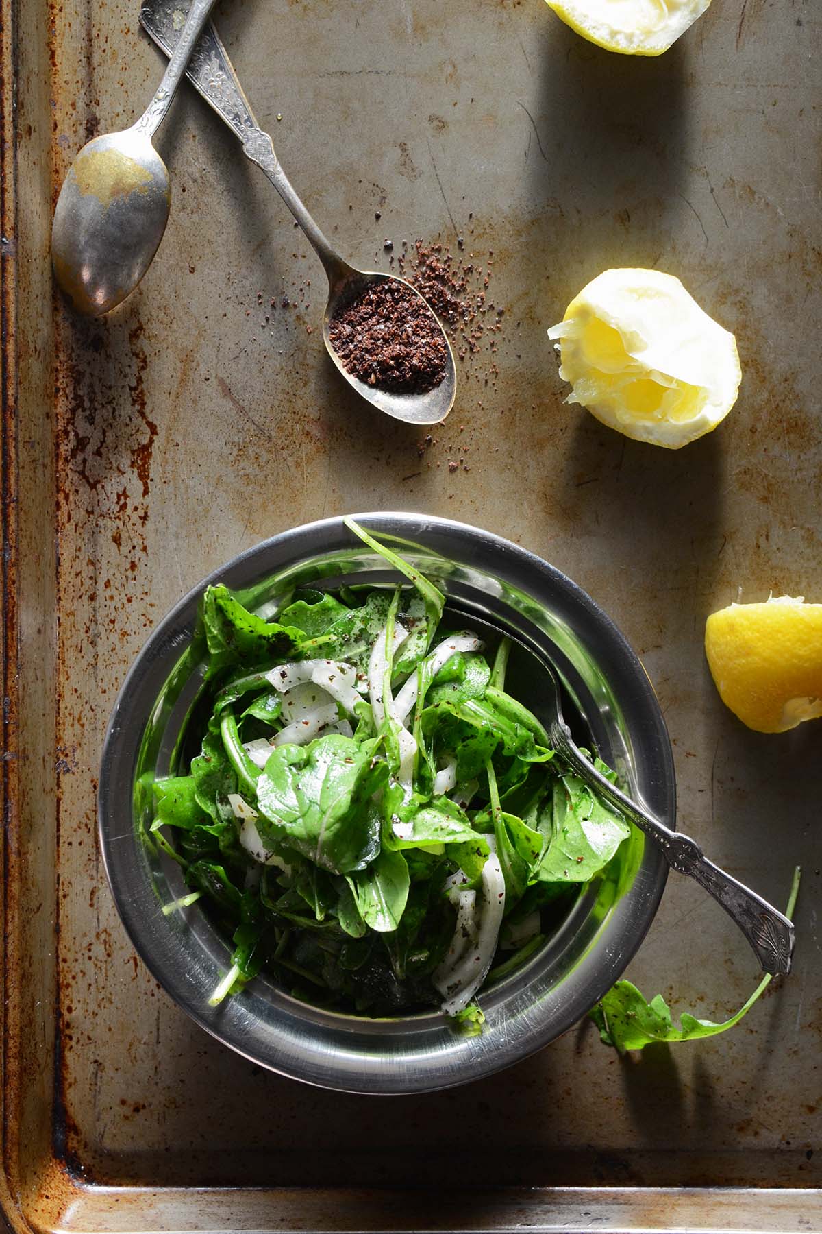 salatat jarjeer in metal bowl on metal tray with sumac