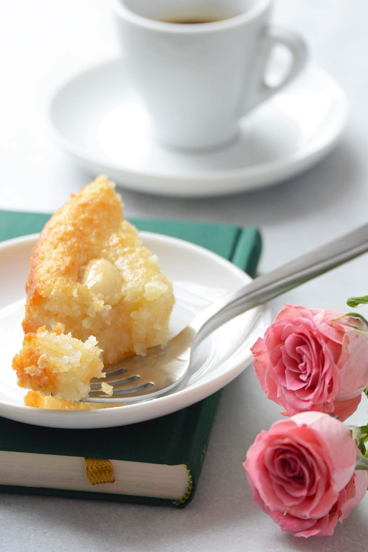 partially eaten slice of cake on plate with fork taking bite