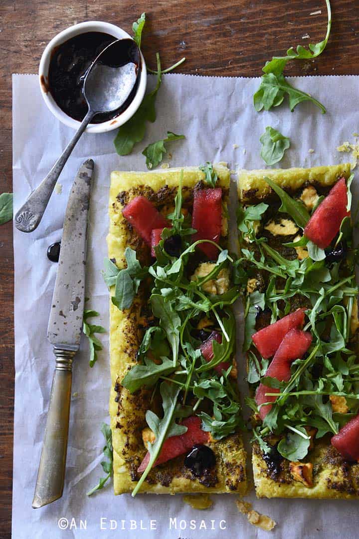 Garlic and Chive Goat Cheese and Pesto Puff Pastry Tart with Arugula, Watermelon, and Strawberry-Balsamic Drizzle Top View, Vertical Orientation