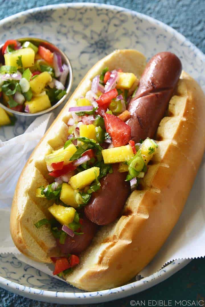 close up of hot dog topped with pineapple relish