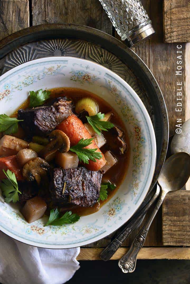 Braised Beef with Root Vegetables and Red Wine on Wooden Table Top View Vertical Orientation