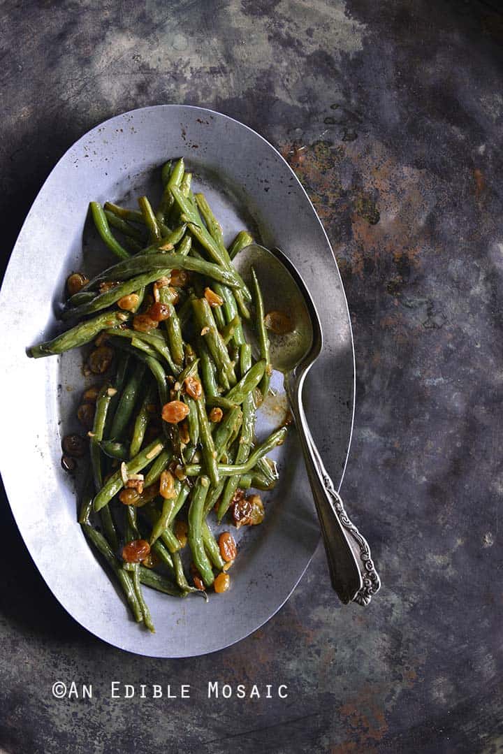 Green Beans with Garlic and Golden Raisins on Metal Tray