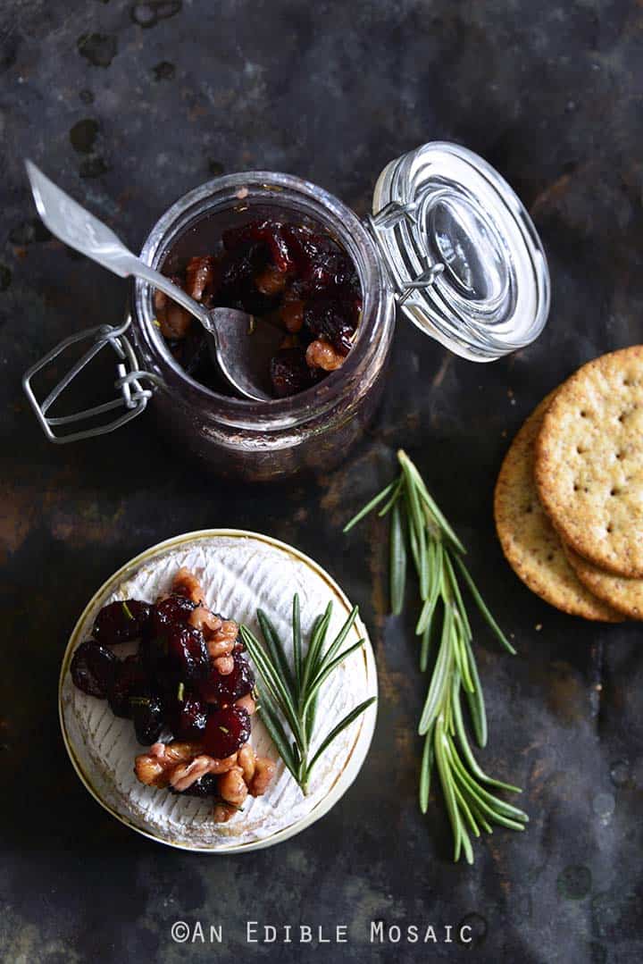 Baked Goat Brie with Spiced Rosemary-Scented Honey and Red Wine Cranberries Overhead View with Crackers