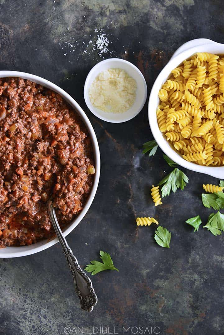 easy beef bolognese in bowl with bowl of pasta