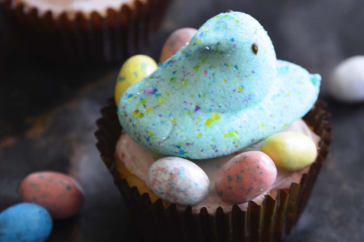 peeps candy on top of cookie cup with pink frosting