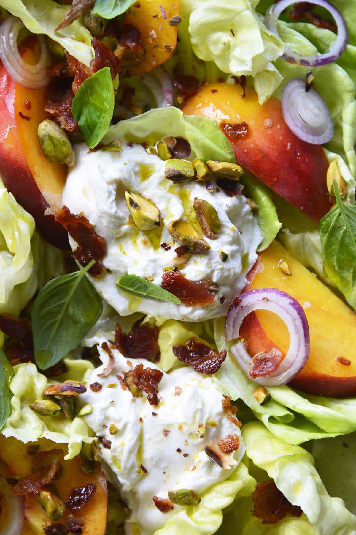 close up top view of peach burrata salad with gem lettuce