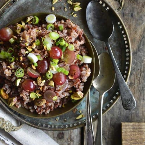 Red Rice Recipe with Grapes and Pistachios on Wooden Table