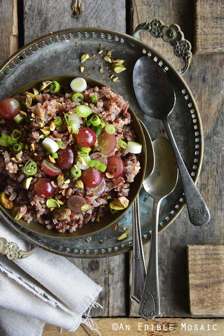 Red Rice Recipe with Grapes and Pistachios on Wooden Table