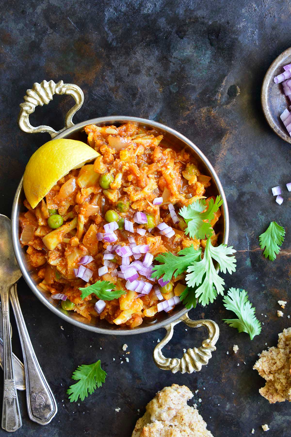 top view of vegetarian Pav Bhaji in metal bowl on dark metal background