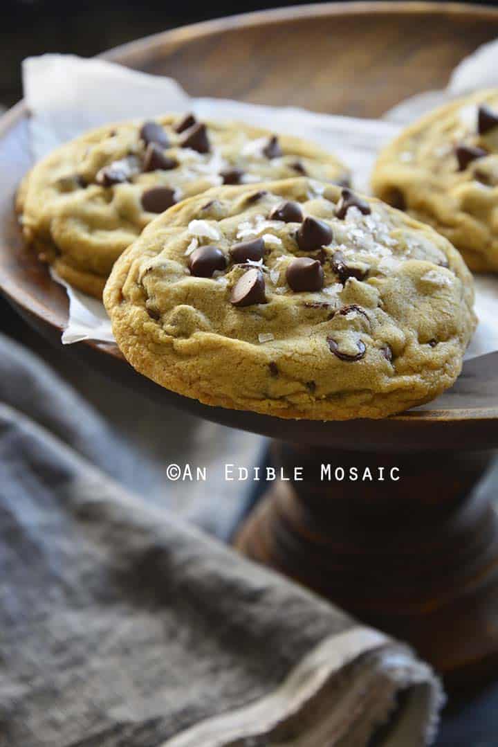 Small Batch Bakery Style Chocolate Chip Cookies on Wooden Pastry Stand with Dark Linen