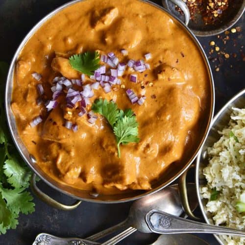 Top View of Easy Low Carb Butter Chicken with Vintage Spoons on Metal Background