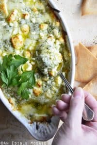 Keto Spanakopita Dip with Hand Holding Spoon in Dip